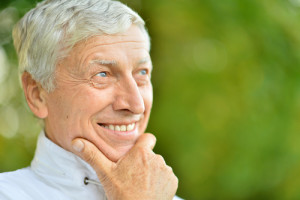 Older Man Smiles and Thinks About the Benefits of Dental Implants