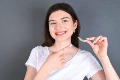 Woman holding Invisalign clear aligner