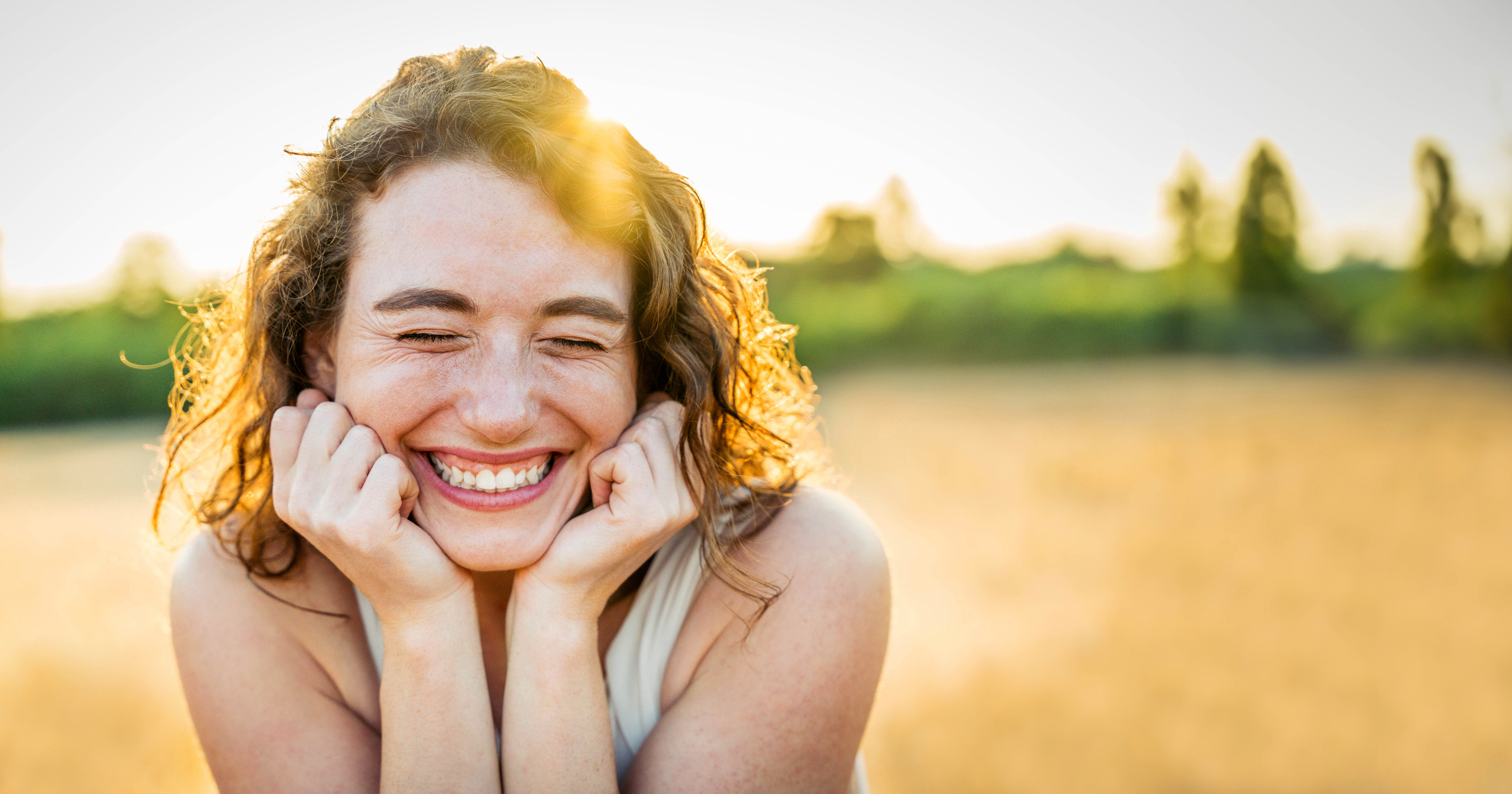 Happy beautiful woman smiling in a wheat field - Delightful female enjoying summertime sunny day outside - Wellbeing concept with confident girl laughing in the nature sheridan wy brighter smile